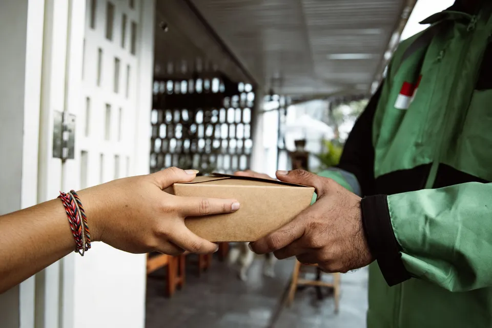 A parcel being handed over at a doorway