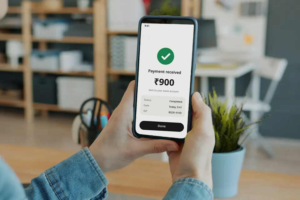 Hands holding a phone that shows a payment received