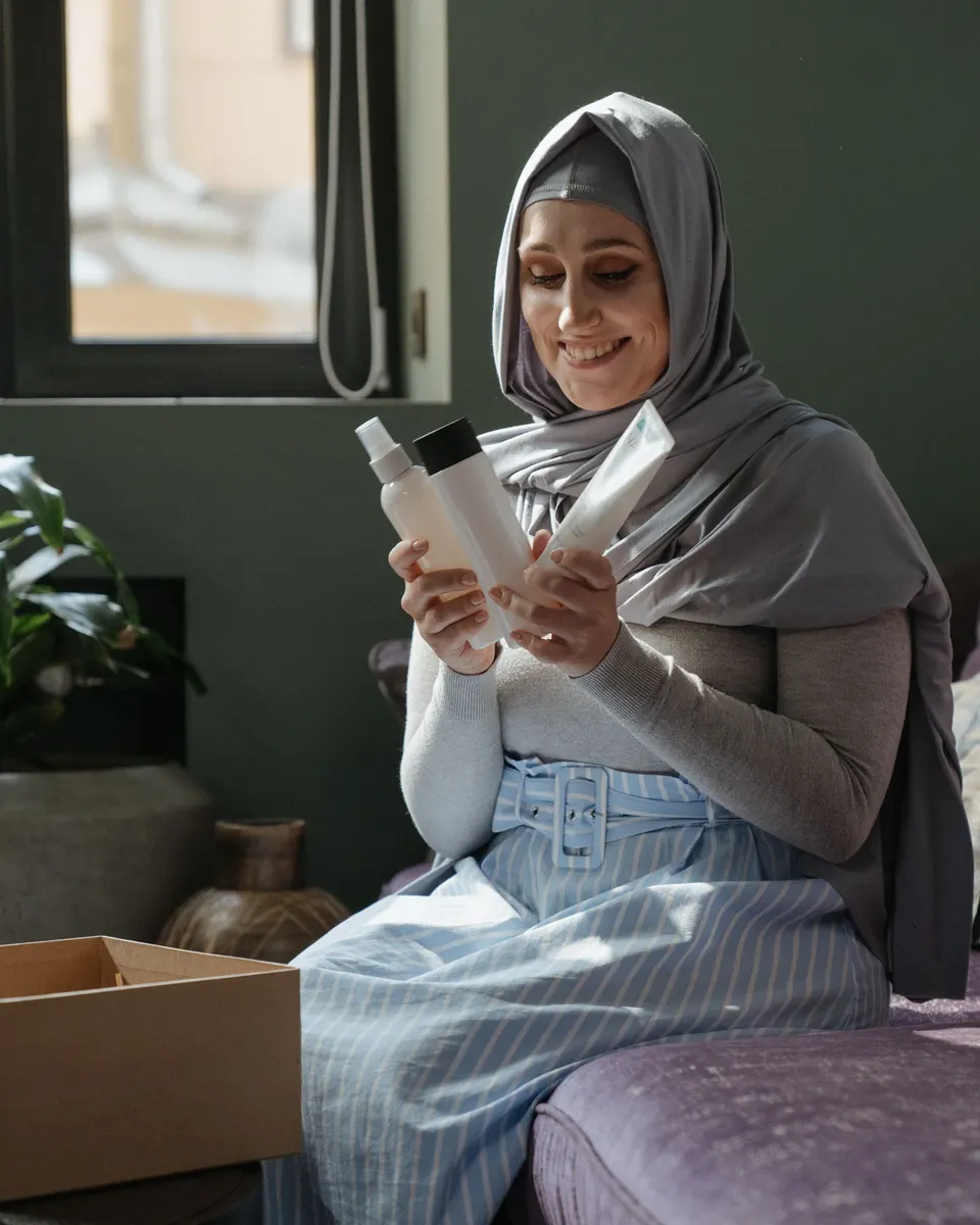 A woman unboxing a skincare bottle at home