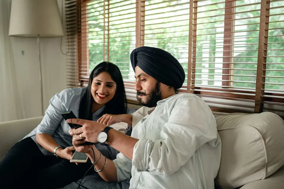 A couple on a sofa looking at a phone together