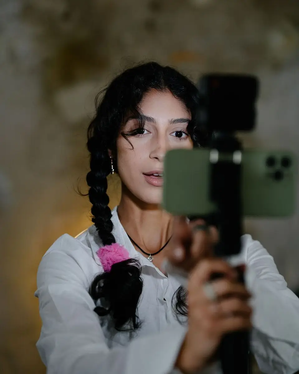 A creator filming herself with a phone on a gimbal