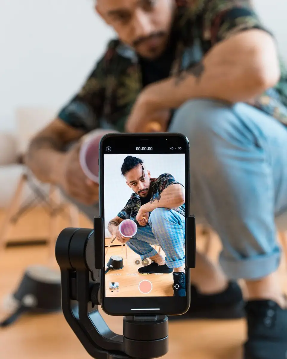 A man filming himself with a phone on a gimbal