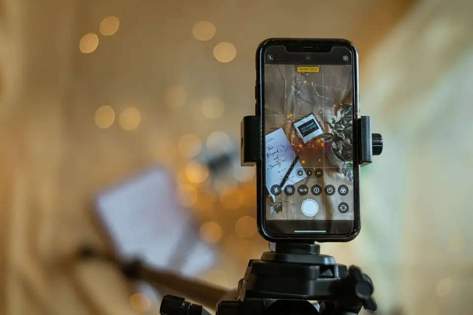 A phone on a tripod filming a product on a table